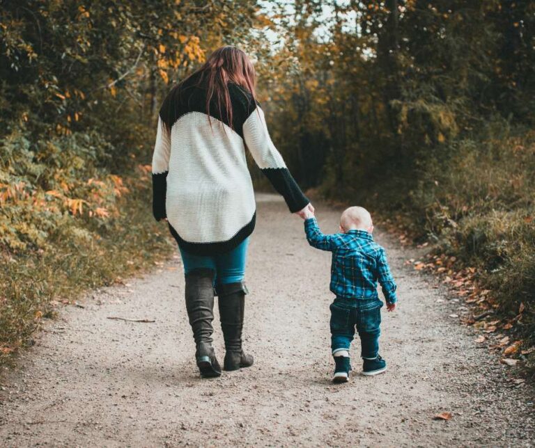 mother with child walking in the forest